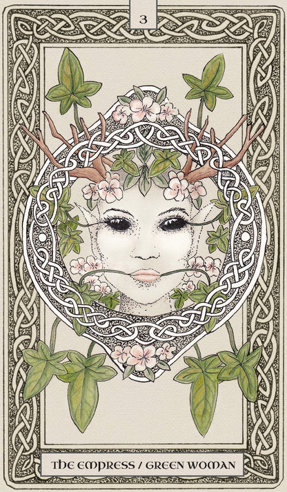 Tarot card featuring a stylized face with antlers and greenery, framed by intricate patterns.