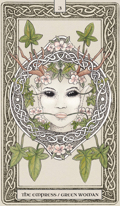 Tarot card featuring a stylized face with antlers and greenery, framed by intricate patterns.