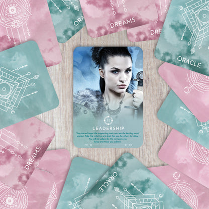 Card with a woman's face surrounded by oracle cards on a wooden surface