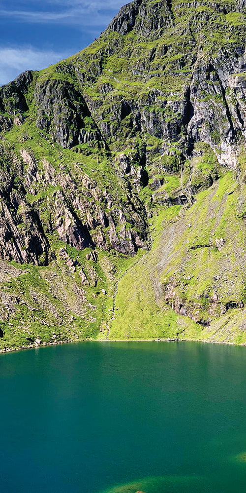 Mountainous landscape with a lake at the foot of a rocky cliff
